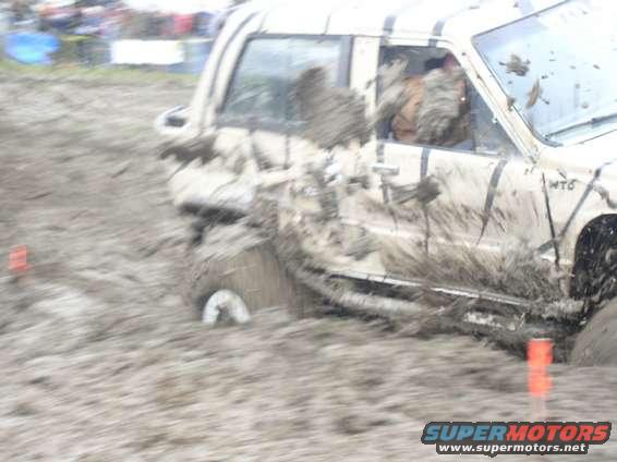 Off-road vehicle covered in mud, stuck in a muddy terrain