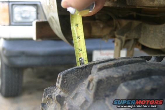 Ford Bronco tire and suspension being measured with a tape measure