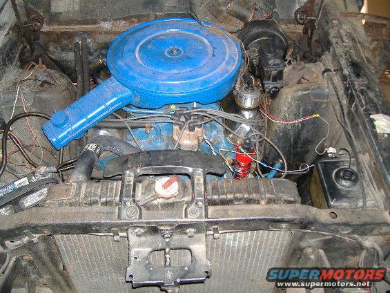 engine bay with blue air cleaner, radiator, and battery