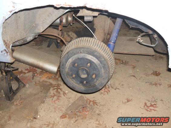 1969 Ford Torino rear wheel and suspension on jack stands, showing drum brake and blue shock absorber