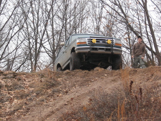 Ford F-Series truck on a dirt hill with a guy standing nearby