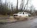 1980 Ford Bronco - A white 1980 Ford Bronco navigates a muddy track, kicking up water as it goes.