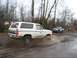 1980 Ford Bronco - A white 1980 Ford Bronco navigates a muddy off-road path, kicking up water and dirt.
