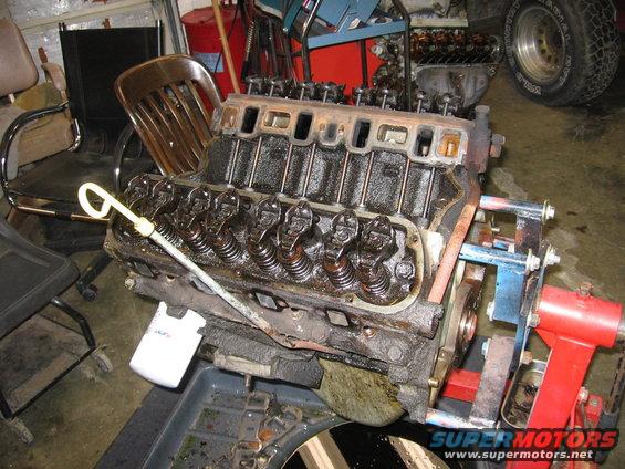 Engine block with oil dipstick and valve covers removed, mounted on an engine stand