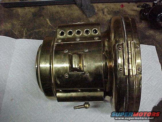 Brass engine component with five circular openings on top