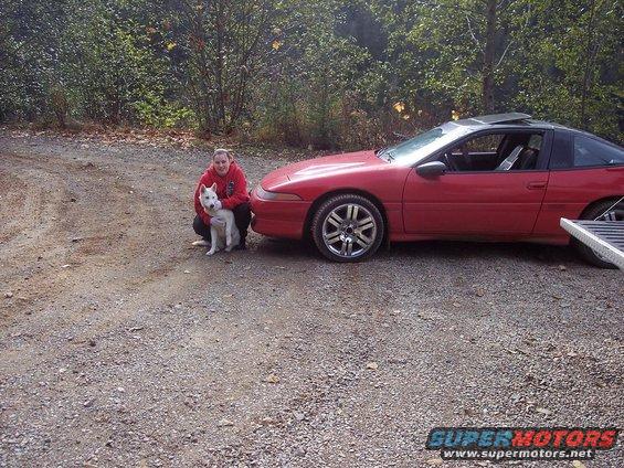 Red 1991 Mitsubishi Eclipse coupe with a person and dog