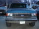 1990 Ford Bronco - This blue Ford F-Series truck has a prominent grille and 4x4 badging, indicating its model year.