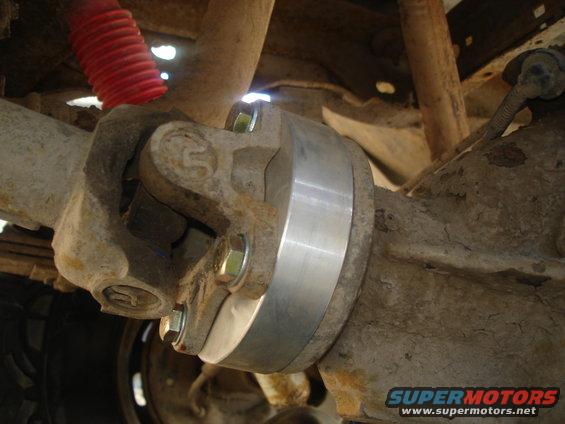 Driveshaft U-joint connected to a differential housing with a silver spacer