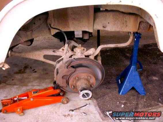 Front wheel assembly on jack stands, orange jack visible