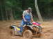 2005 Honda RANCHER - An ATV is stuck deep in the mud with a man trying to get it out.