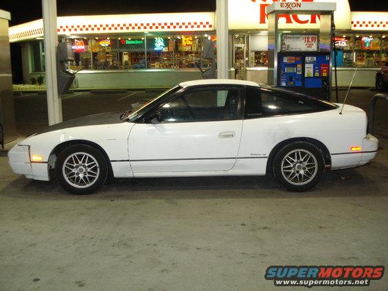 White 1991 Nissan 240SX parked at a gas station at night