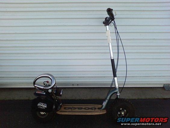 Motorized scooter with knobby tires and a chrome exhaust pipe