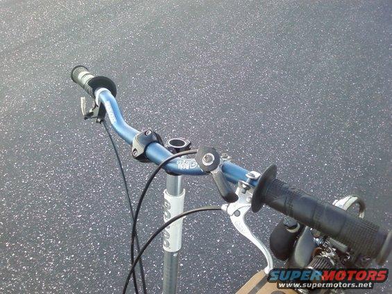 Blue handlebars with black grips and brake lever on a scooter