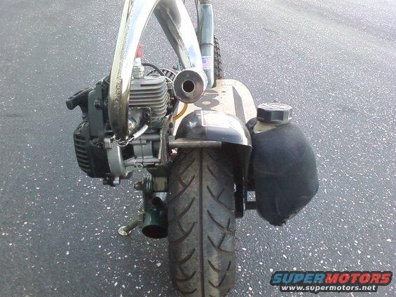 Rear view of a go-ped scooter showing the engine, exhaust, tire, and fuel tank