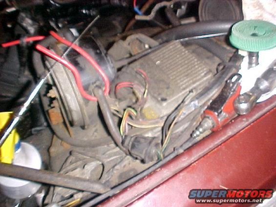 Engine ignition module with red and black wires connected. A green cap is visible on a component to the right