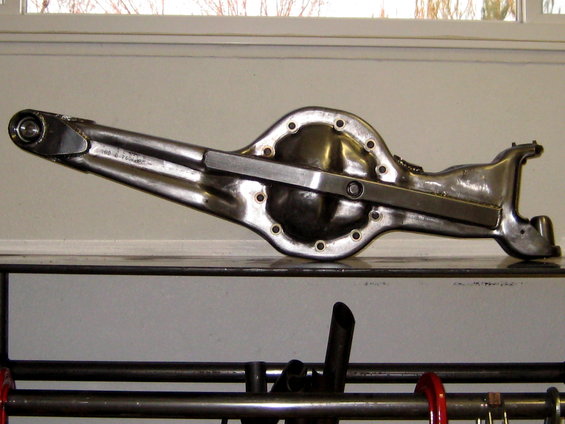 Polished metal rear axle differential housing with a metal bar across the top