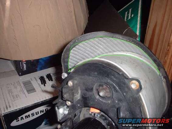 Close-up of a car headlight assembly with a green-lined air filter visible