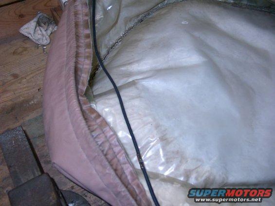 Pink and white spare tire cover interior with black cable