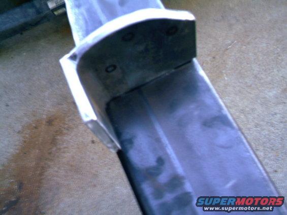 Metal rear bumper section with visible mounting holes and a dark grey finish