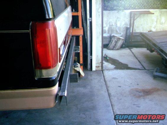 Black and tan SUV rear bumper with a metal bar attached, seen from the side
