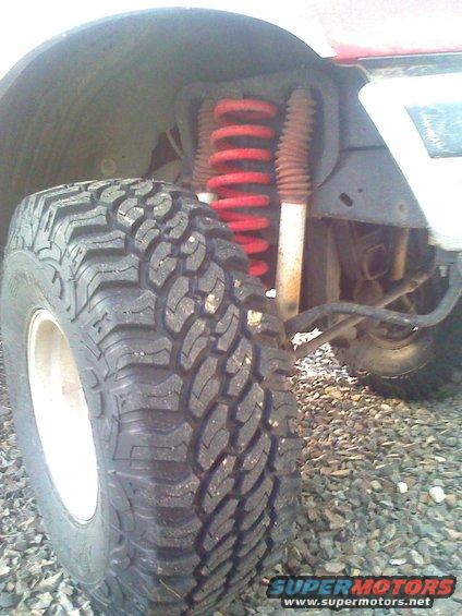 Off-road tire and red coil spring suspension on a vehicle