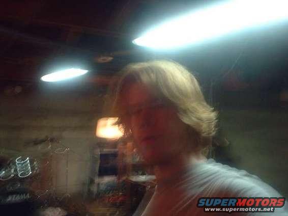 Person with blond hair in a dimly lit garage