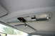 1996 Ford Bronco - The overhead console of a 1996 Ford Bronco shows an opening with exposed wiring and a partially lowered sun visor.