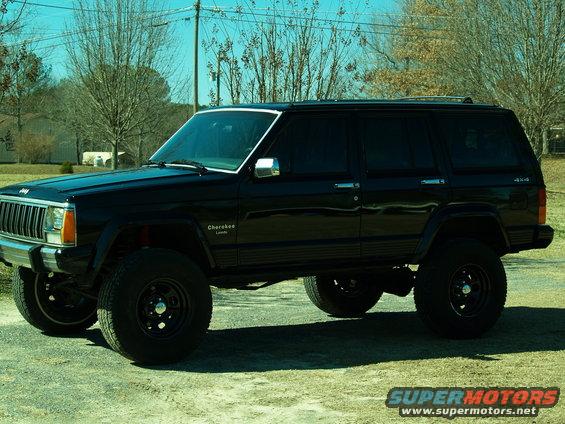 Black Jeep Cherokee with lifted suspension and aftermarket wheels parked outside