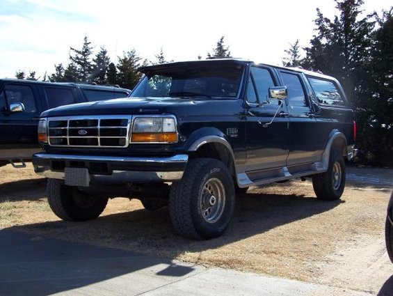1995 Ford C-350 (Centurion Conversions) parked outdoors, another dark SUV behind it