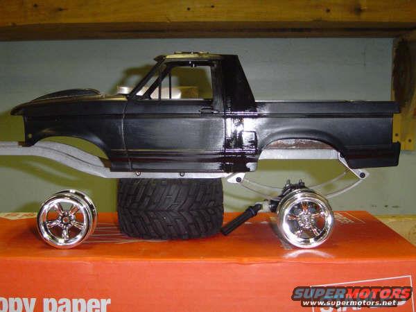 Model of a black 1993 Ford Bronco with chrome wheels and a tire