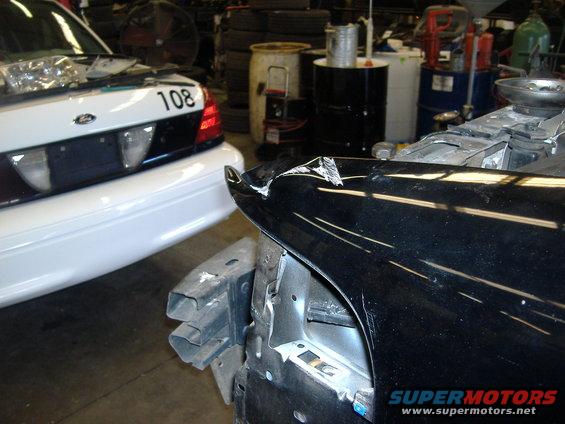 Black Ford Crown Victoria fender damaged, white Ford Crown Victoria behind it with number 108 on trunk