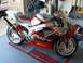 1978 Ford Bronco - A red and silver Honda RC51 motorcycle is parked on a Honda-branded mat inside a garage.