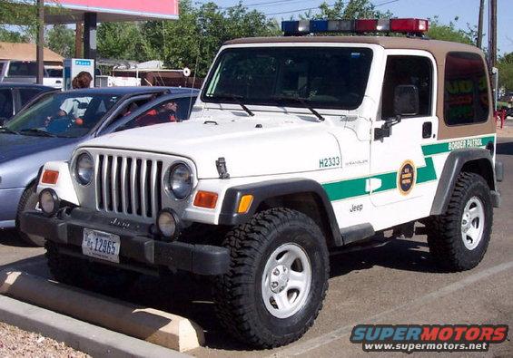 White Jeep Wrangler with green stripe and "Border Patrol" text, equipped with light bar