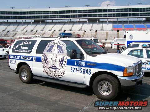 Dallas Police SUV with 'Recruiting Team' and phone number on the side, parked near a stadium