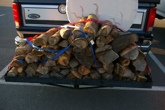 Ford pickup truck's rear end loaded with firewood on a carrier