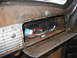 1949 Chevrolet C/K Pickup - Interior view of a rusty glove box containing various old parts and spark plugs.