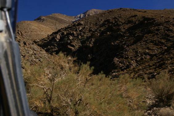 Interior view of vehicle looking out at rocky desert mountains