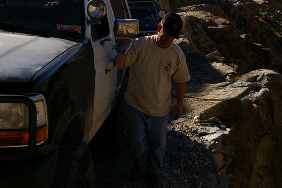 Two-tone SUV on rocky trail, man exiting