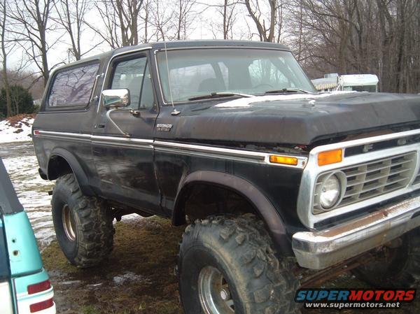 Black 1979 Ford Bronco with large off-road tires, 3/4 front view