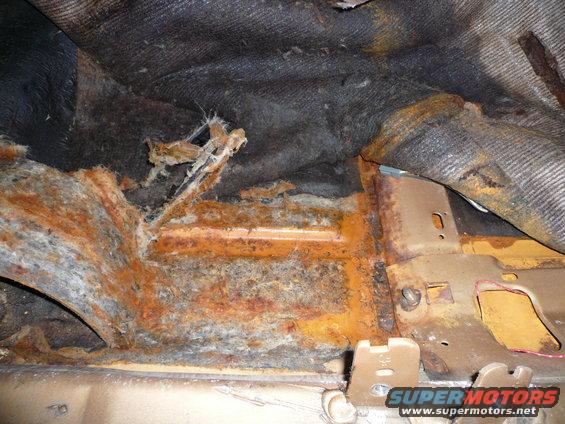rusted metal and torn upholstery inside a vehicle