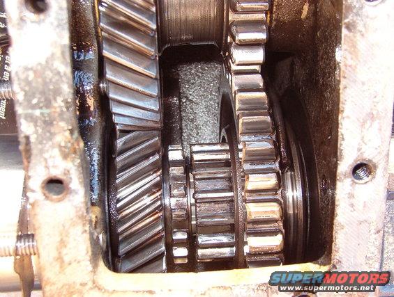 08lo2.jpg The output gear (lower R) is slid rearward on the output shaft to engage the smaller center gear (upper L) providing low-range.