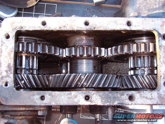 11lo4.jpg With both output gears slid rearward, the t-case is in 4L.

The Aluminum sleeve & stub shaft at the lower R are for the Advance Adapters kit for the AOD.  Removing that shaft from the t-case allows about a dozen roller bearings to fall loose into & out of the t-case.  Finding & re-installing them is a challenge.