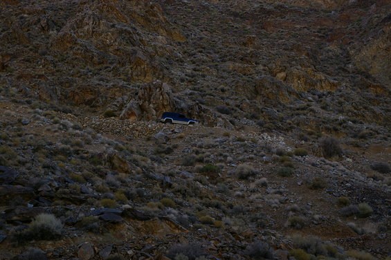 Dark blue 1986 Ford Bronco parked on a rocky, barren hillside