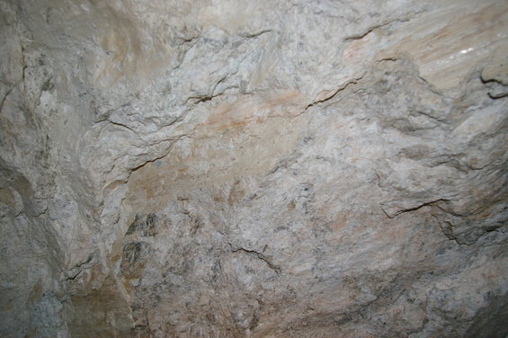Close-up of a rough, textured rock face with layers and cracks