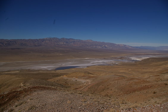 Wide view of a desert valley with mountains in the distance and a dry lake bed