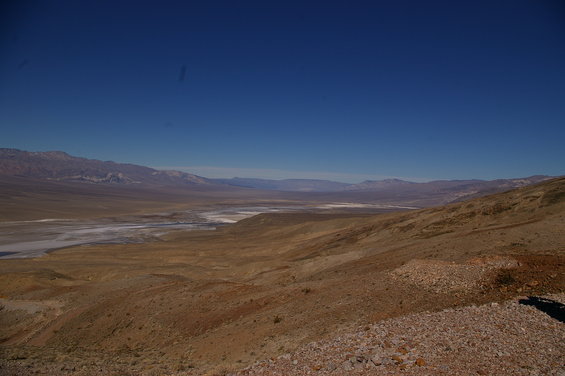 Desert landscape with mountains in the distance under a clear blue sky