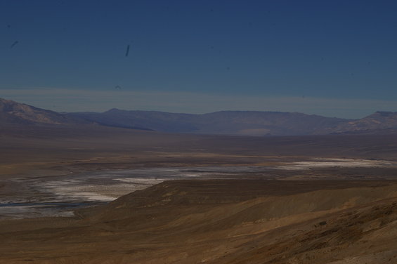 Vast desert landscape with mountains under a clear blue sky