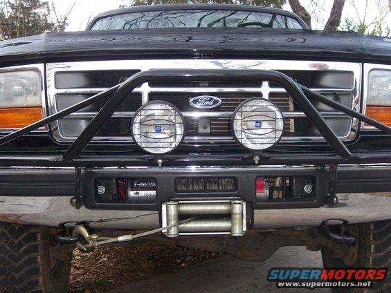Black Ford Bronco front end with chrome grille, bull bar, winch, and fog lights