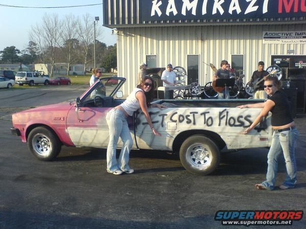 1981 Dodge Power Ram pickup truck, pink and white, convertible top, graffiti on bed, two women posing