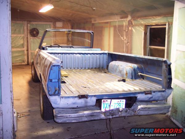 1981 Dodge Power Ram pickup truck, rear view, in a garage. Blue paint, some rust visible